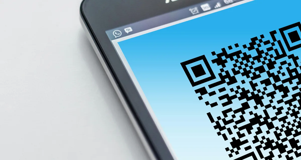 High-resolution close-up of a smartphone displaying a QR code on its screen.